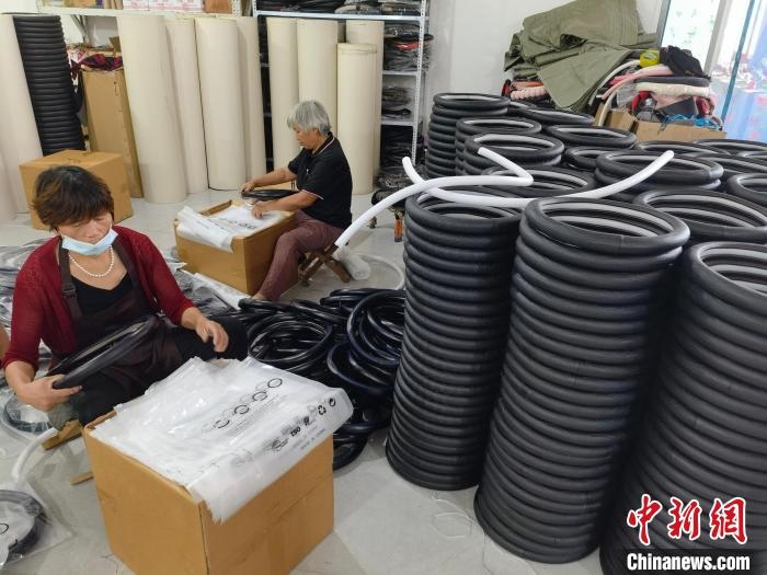 圖為村民在汽車飾品企業(yè)生產(chǎn)車間中工作?！巫雍?攝