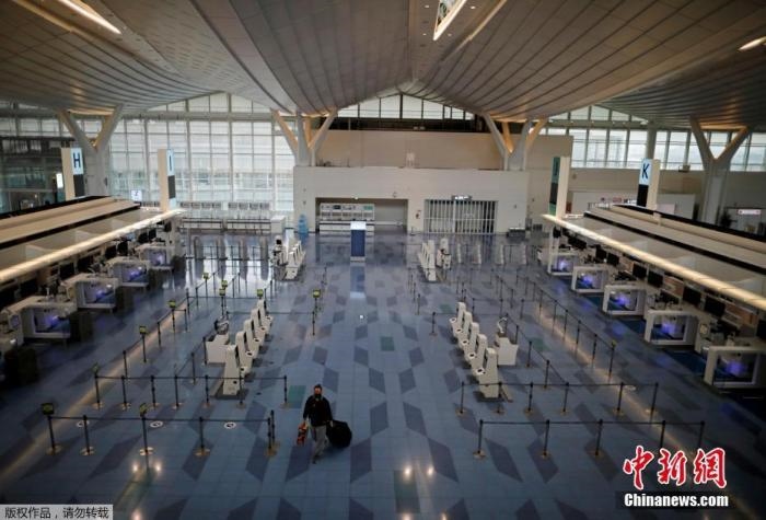 資料圖：日本東京，東京國際機(jī)場，一名乘客在國際航班航站樓的登機(jī)區(qū)。