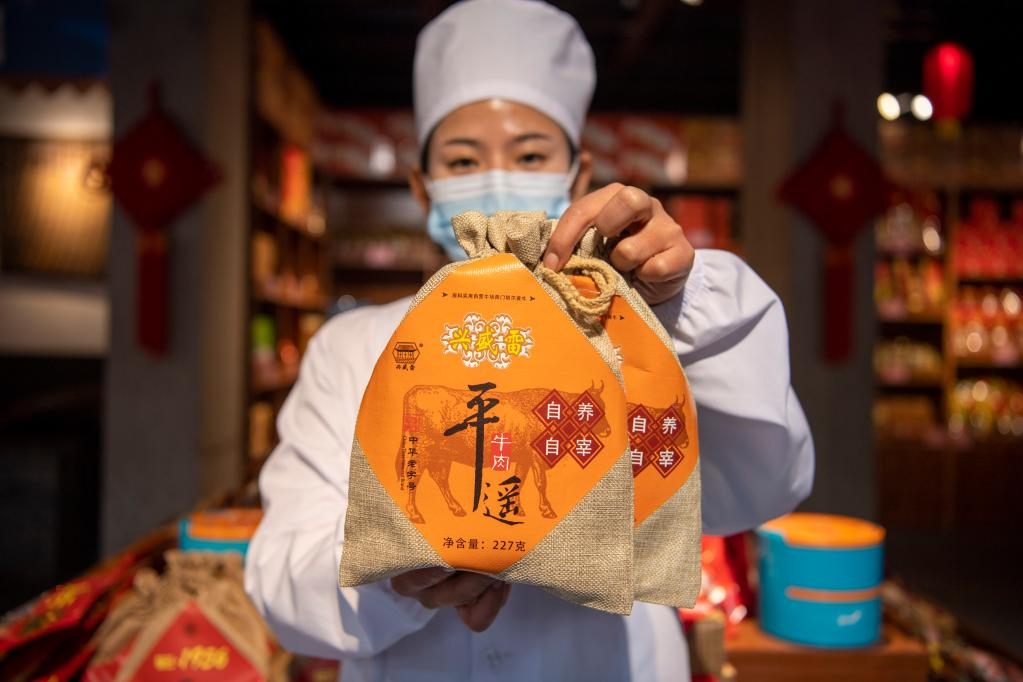 1月27日，在平遙古城南大街的一家平遙牛肉店內(nèi)，工作人員展示一款牛肉產(chǎn)品。新華社記者 楊晨光 攝