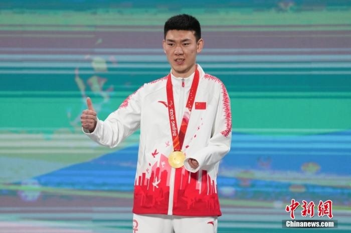 3月6日，梁景怡在延慶頒獎(jiǎng)廣場(chǎng)領(lǐng)獎(jiǎng)臺(tái)上豎起大拇指。當(dāng)日，在國(guó)家高山滑雪中心舉行的北京2022年冬殘奧會(huì)殘奧高山滑雪男子超級(jí)大回轉(zhuǎn)—站姿決賽中，中國(guó)選手梁景怡奪得冠軍。 <a target='_blank' href='/'>中新社</a>記者 楊華峰 攝