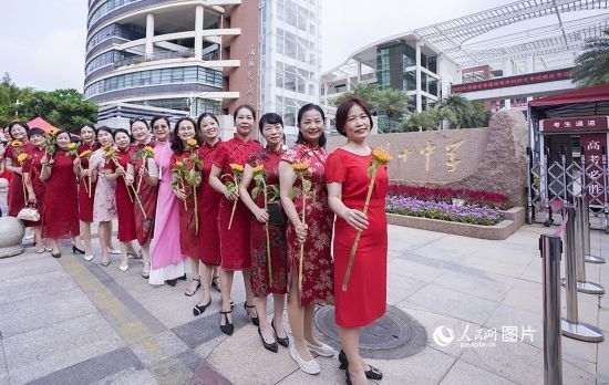 6月7日一早，廈門雙十中學考生家長們身穿旗袍，手拿向日葵在考場外為孩子加油打氣，寓意“旗開得勝，一舉奪魁”。人民網記者 陳博攝