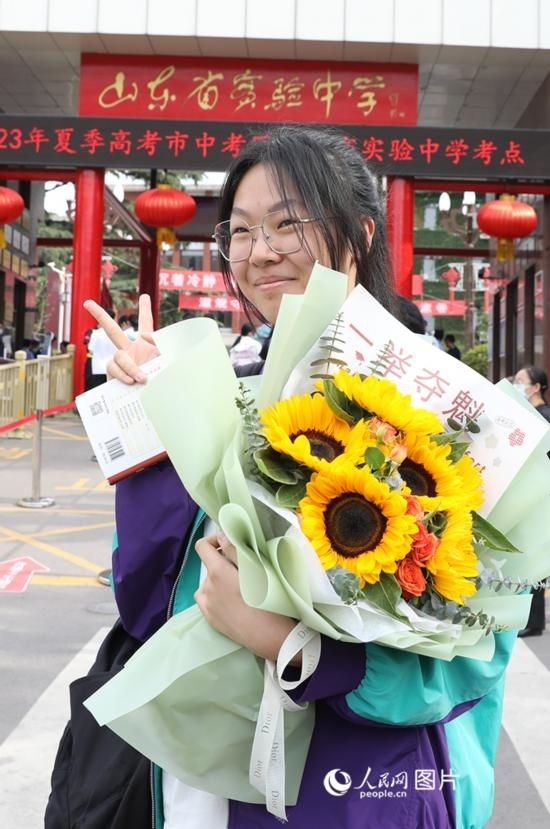 6月7日高考首日，山東67萬考生走進考場，拼搏逐夢。在山東省實驗中學考點，考生進考場前手捧向日葵花拍照留念，寓意“一舉奪魁”。人民網記者 劉祺攝