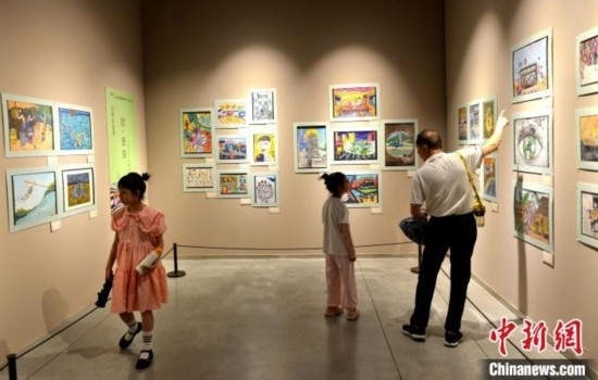 圖為家長(zhǎng)帶著孩子參觀(guān)展覽。呂明 攝