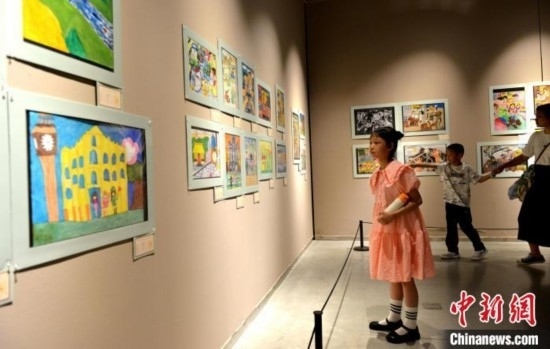 圖為家長(zhǎng)帶著孩子參觀(guān)展覽。呂明 攝