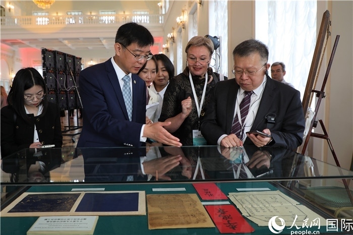 中俄圖書館論壇嘉賓共同參觀由俄羅斯國立列寧圖書館舉辦的館藏中國古籍善本圖書展。人民網(wǎng)記者 隋鑫攝）