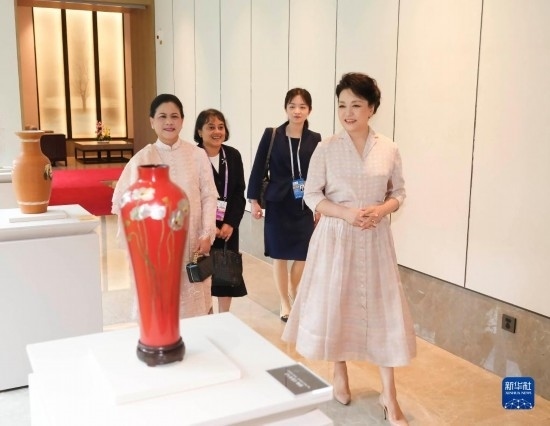 7月27日下午，國(guó)家主席習(xí)近平夫人彭麗媛在四川成都會(huì)見陪同印度尼西亞總統(tǒng)佐科來(lái)華出席第31屆世界大學(xué)生夏季運(yùn)動(dòng)會(huì)開幕式并訪華的總統(tǒng)夫人伊莉亞娜。這是彭麗媛和伊莉亞娜欣賞成都特色非遺工藝品。新華社記者 丁林 攝