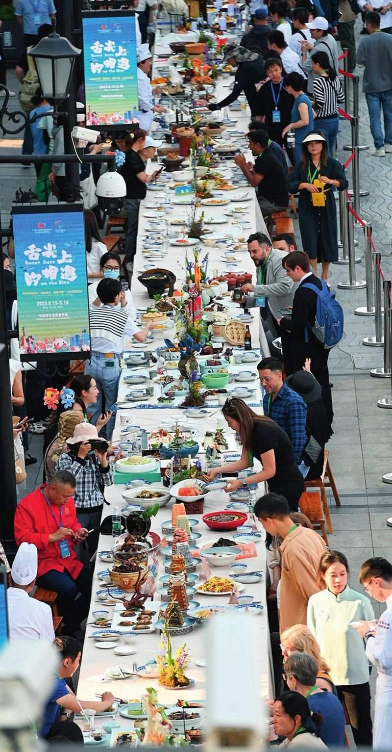 市民和游客在寧波舉辦的第三屆中國—中東歐國家博覽會(huì)暨國際消費(fèi)品博覽會(huì)上品嘗融合中國和中東歐美食的長桌宴（2023年5月15日攝）。黃宗治攝/本刊