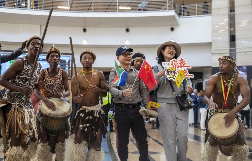 在南非約翰內(nèi)斯堡坦博國際機場，南非舞蹈演員歡迎中國試點恢復出境團隊旅游后首批抵達南非的中國游客（2023年3月29日攝）。