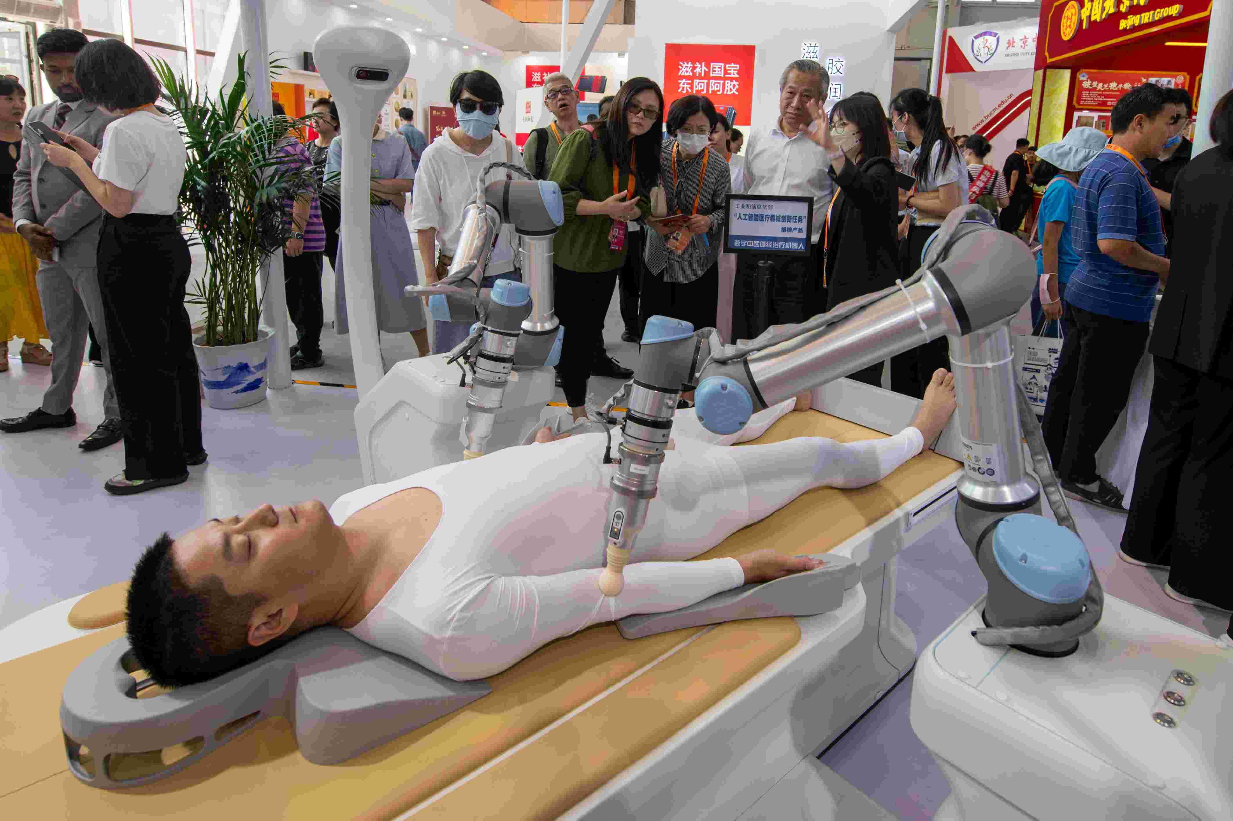 在位于首鋼園的健康衛(wèi)生服務(wù)展區(qū)，觀眾正在參觀數(shù)字中醫(yī)循經(jīng)治療機(jī)器人。人民網(wǎng)記者 翁奇羽攝