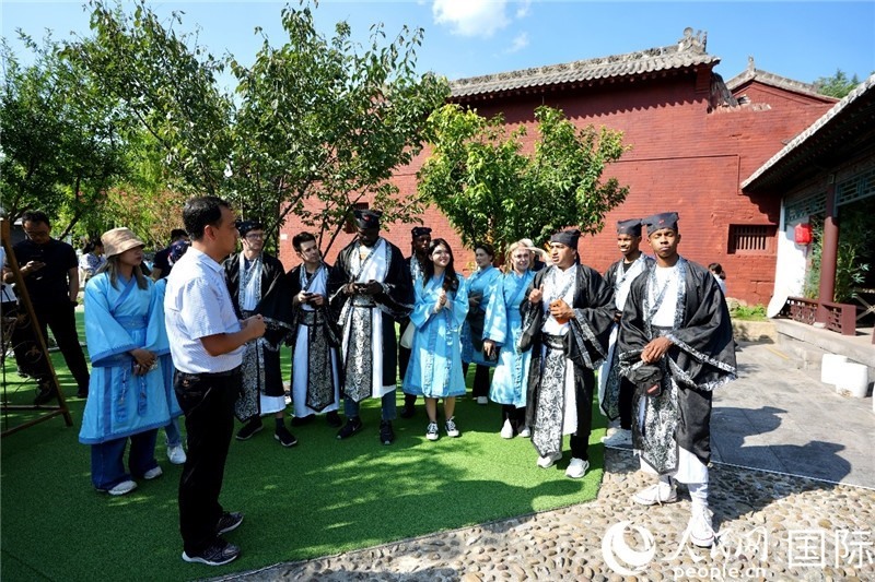 圖為選手們聽導(dǎo)游講解。人民網(wǎng) 盧鵬宇攝