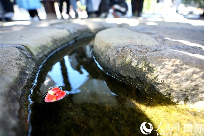 圖為水渠里流過(guò)的“桃心”蠟燭。人民網(wǎng) 盧鵬宇攝