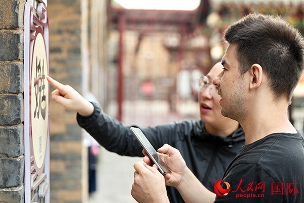 選手安德烈（俄羅斯）在老師指導下學習墻壁上張貼的生僻字。人民網(wǎng) 盧鵬宇攝