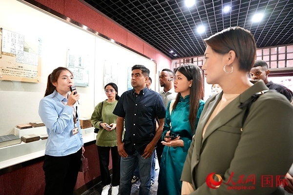 選手們認真聆聽導游講解。人民網(wǎng) 盧鵬宇攝