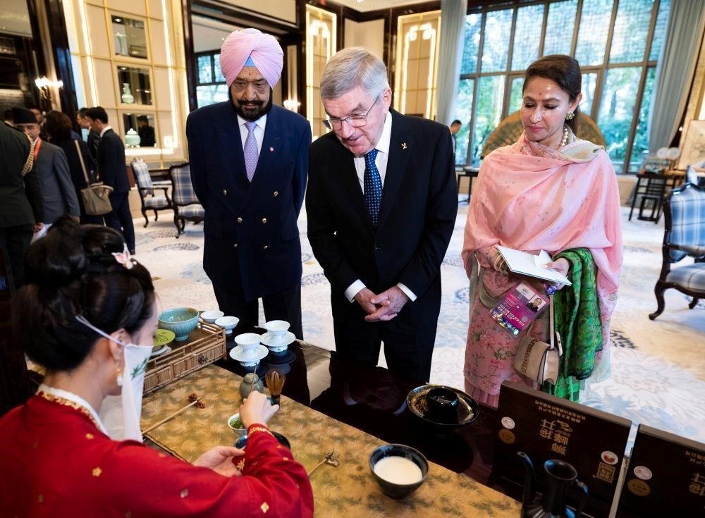 △歡迎宴會前，亞奧理事會代理主席辛格和夫人維尼塔、國際奧委會主席巴赫欣賞非遺展示。