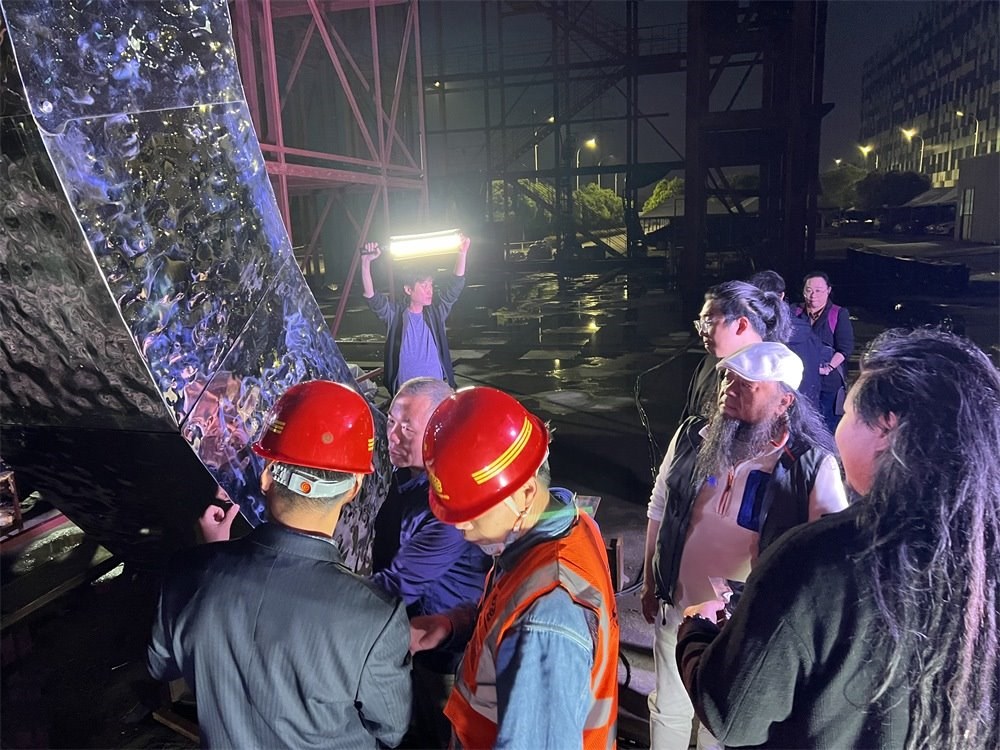 林崗（右二）和團隊查看主火炬制作進度。受訪者供圖