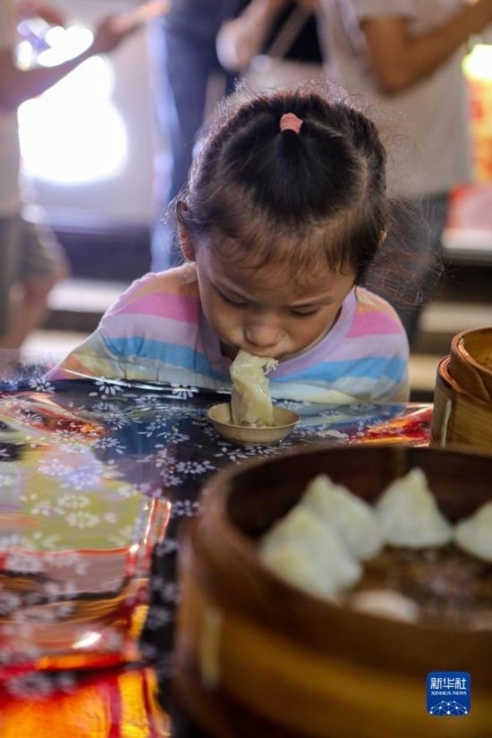 9月27日，小朋友在南翔小籠長街宴上品嘗南翔小籠。