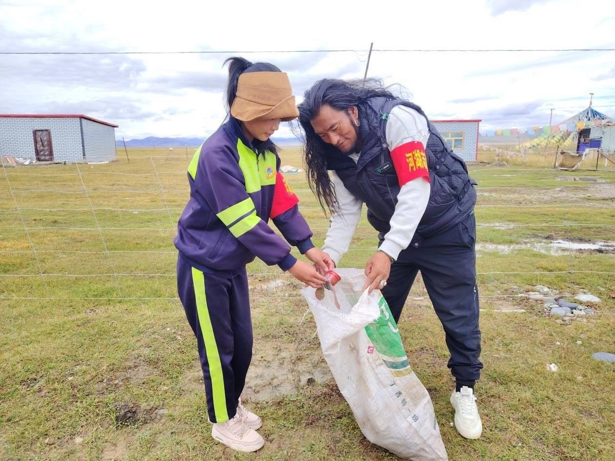 玉樹州稱多縣珍秦鎮(zhèn)河湖志愿者才培和他女兒更求拉毛在清掃垃圾。受訪者供圖
