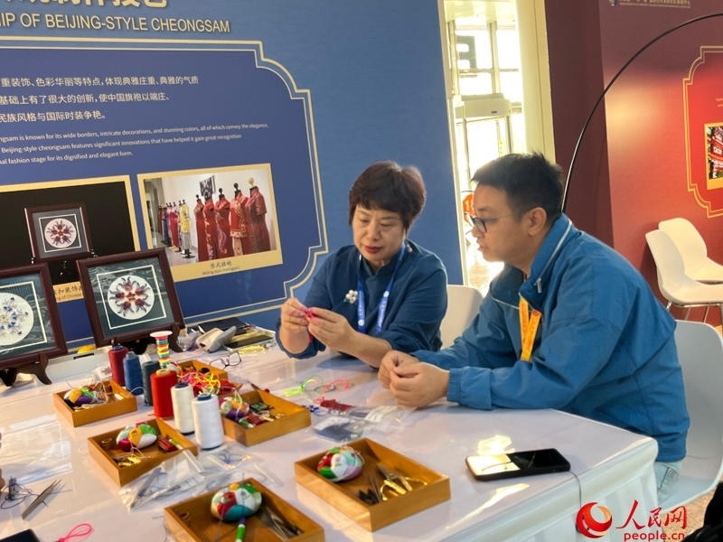 記者在新聞中心非遺傳承人展區(qū)進(jìn)行體驗(yàn)。人民網(wǎng)記者 杜燕飛攝