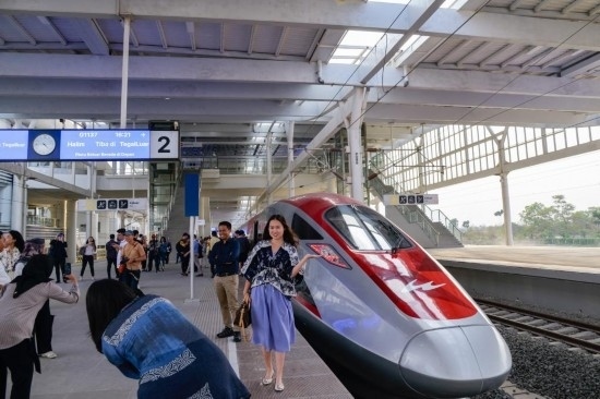  10月17日，在印度尼西亞萬隆德卡魯爾站，乘客在站臺上和雅萬高鐵高速動車組列車合影。新華社記者 徐欽 攝