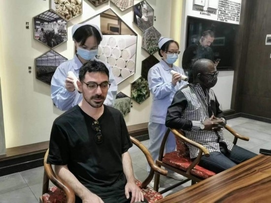 2023“一帶一路”媒體合作論壇聯(lián)合采訪團團員在九牛草展示館體驗艾灸。（本報記者 黃超攝）
