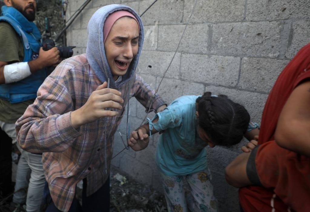 11月6日，人們從加沙地帶中部地區(qū)一處被炸難民營逃離。新華社發(fā)（亞西爾·庫迪攝）