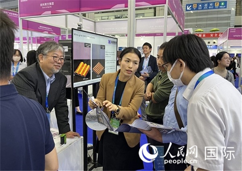 工作人員向參觀者介紹超級(jí)噴墨技術(shù)。（人民網(wǎng)記者 陳思攝）