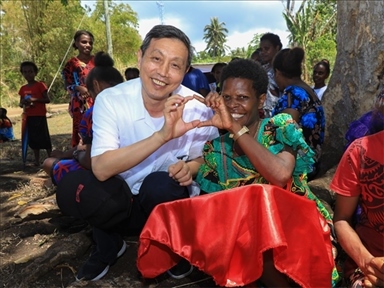 2023年12月18日，中國駐瓦努阿圖大使李名剛和前來觀看瓦努阿圖公路項目二期馬勒庫拉段移交儀式的當?shù)鼐用窈嫌?。人民網(wǎng) 賀吉攝