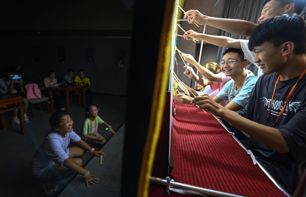 2023年8月8日，進行暑期研學的學生在位于陜西省西安市的中國秦腔藝術博物館體驗皮影戲演出。新華社記者 鄒競一 攝