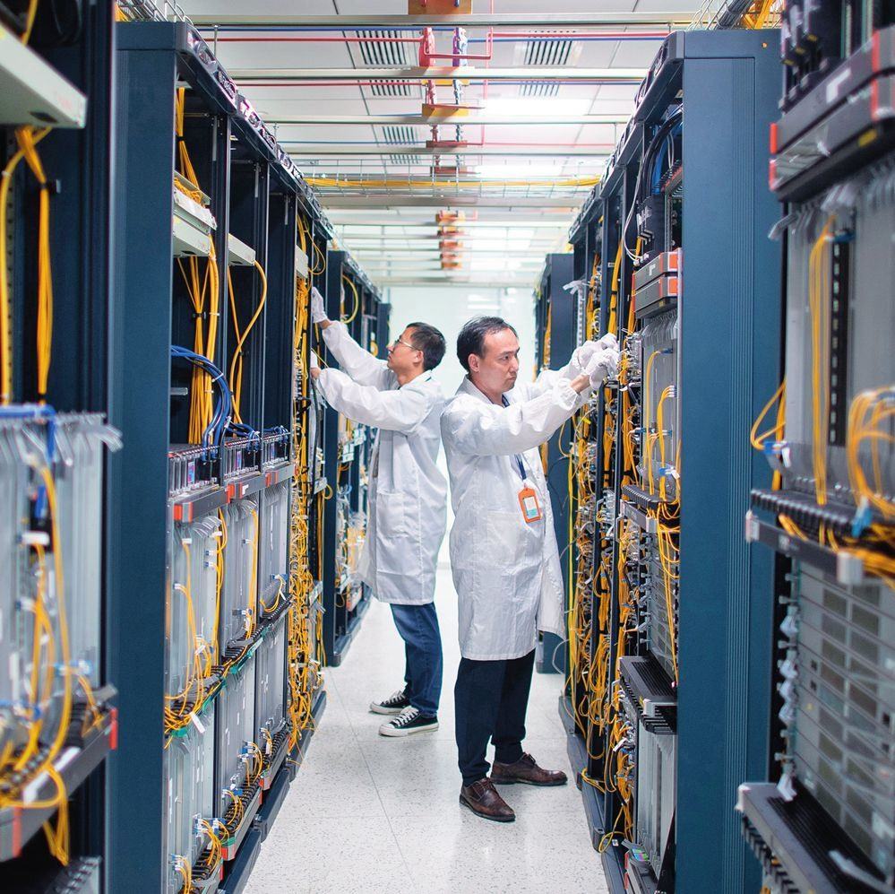 在位于武漢中國(guó)光谷的光電器件研發(fā)制造商——武漢光迅科技股份有限公司生產(chǎn)車間內(nèi)，技術(shù)人員在光模塊生產(chǎn)線作業(yè)（2023年4月11日攝）。程敏攝/本刊