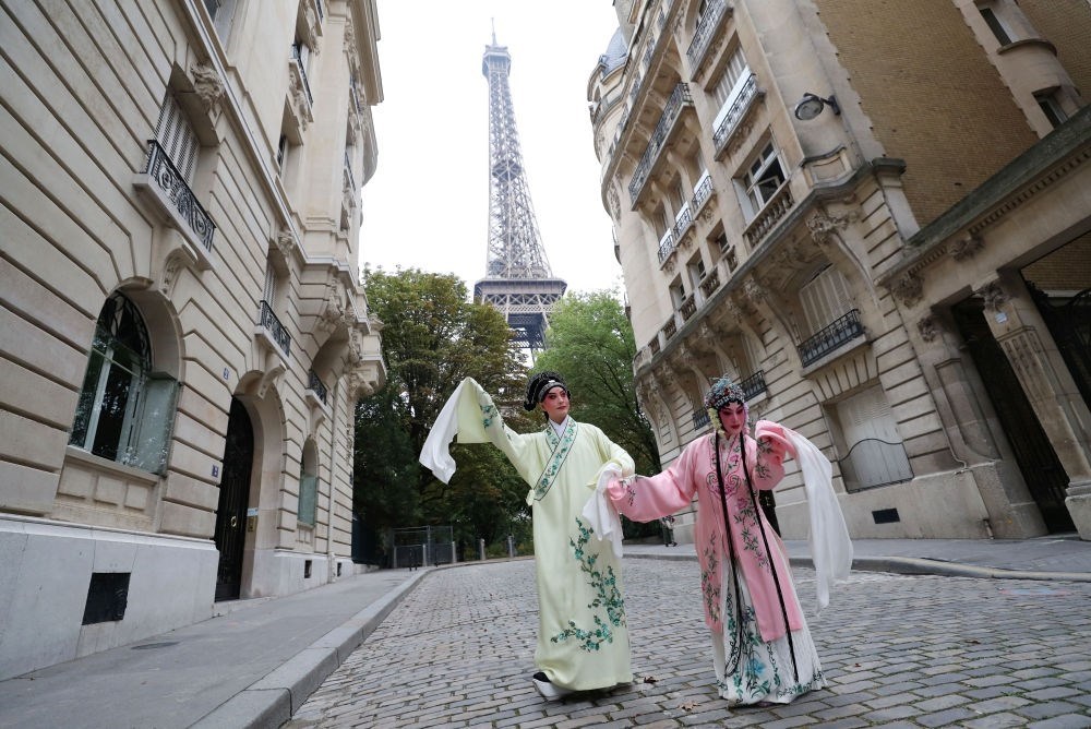 2023年9月13日，江蘇省演藝集團昆劇院院長施夏明（左）和江蘇省演藝集團昆劇院國家一級演員孔愛萍在法國巴黎埃菲爾鐵塔附近參加昆曲快閃。新華社記者 高靜 攝