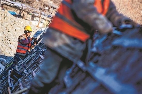 1月3日，房山區(qū)，工人正在雙泉河修筑堤壩。