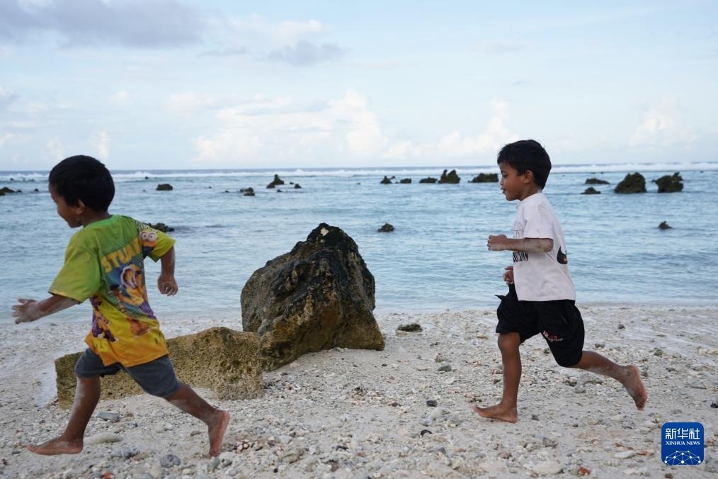 1月20日，兒童在瑙魯海邊嬉戲。新華社記者 王申 攝