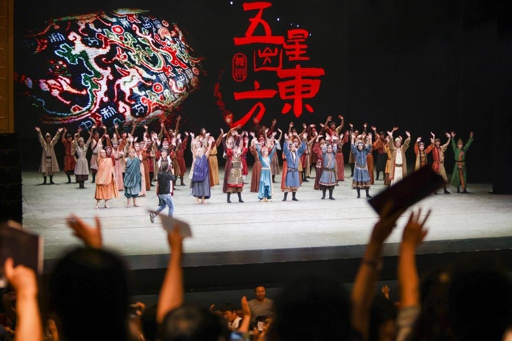 2023年7月31日，新疆和田地區(qū)新玉歌舞團在烏魯木齊京劇院演出舞劇《五星出東方》后和觀眾互相揮手致意。這場演出是第六屆中國新疆國際民族舞蹈節(jié)的參演劇目之一，曾榮獲國家“文華獎”等。新華社記者 郝昭 攝