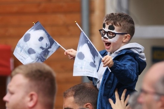  2023年7月26日，在法國(guó)圣艾尼昂市博瓦勒野生動(dòng)物園外，一名兒童等待送別熊貓“圓夢(mèng)”。新華社記者 高靜 攝