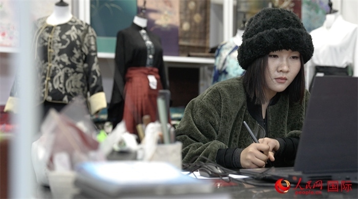 1月23日，在山東省菏澤市曹縣有愛云倉直播基地，張子晨正在設(shè)計漢服。 人民網(wǎng)記者 袁蒙攝