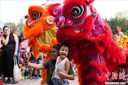 圖為舞獅表演吸引民眾合影。張興龍攝