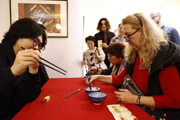 羅馬尼亞觀眾體驗(yàn)用筷子夾花生。中國(guó)文化中心供圖