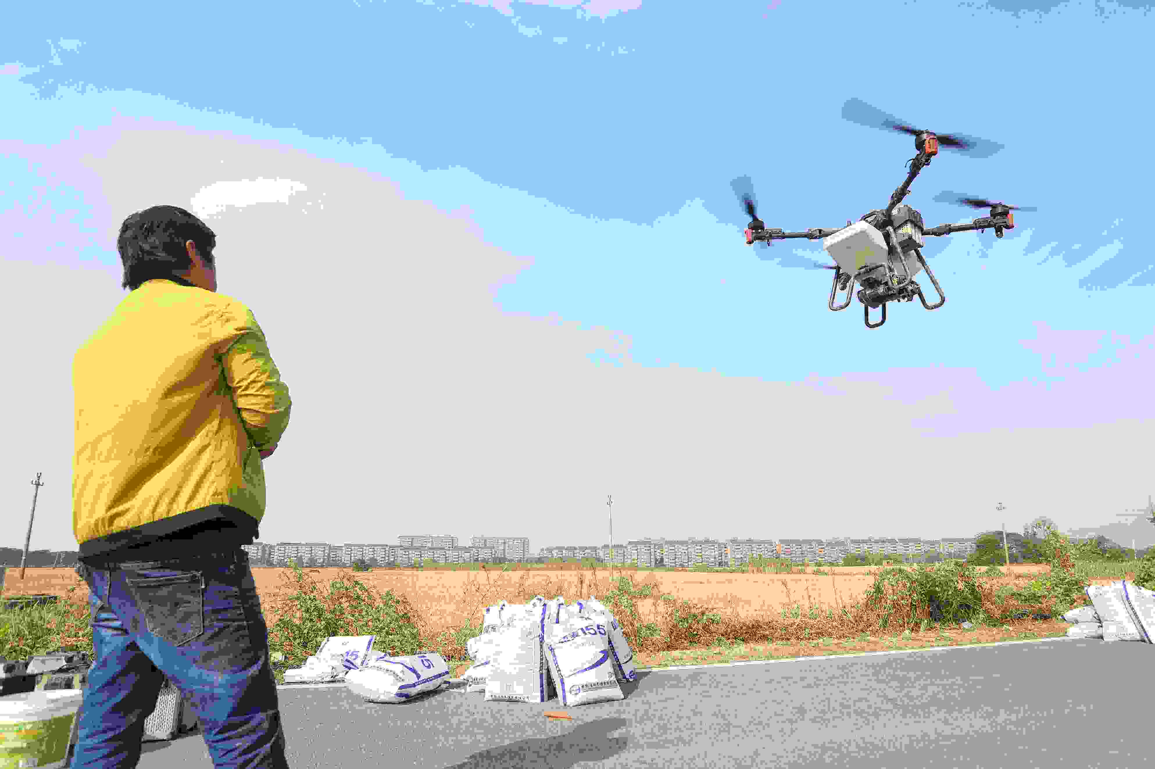 2023年11月15日，浙江嘉興，南湖區(qū)七星街道一處農(nóng)田里，農(nóng)民操縱無人機進行冬小麥飛播。