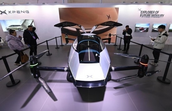 2023年12月1日，在鏈博會(huì)智能汽車鏈展區(qū)小鵬汽車展臺(tái)，參觀者觀看一臺(tái)智能飛行器。新華社記者蔡湘鑫攝