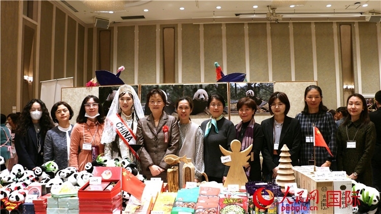 中國駐日本大使吳江浩夫人丁玥（左五）與使館人員在展位前合影留念。人民網(wǎng) 許可攝