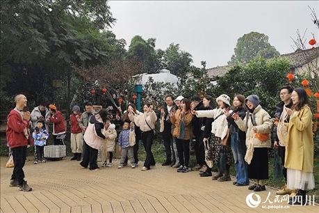 葉科（左一）給前來參與活動(dòng)的“柑爸柑媽”介紹生態(tài)種植果。人民網(wǎng)記者朱虹攝