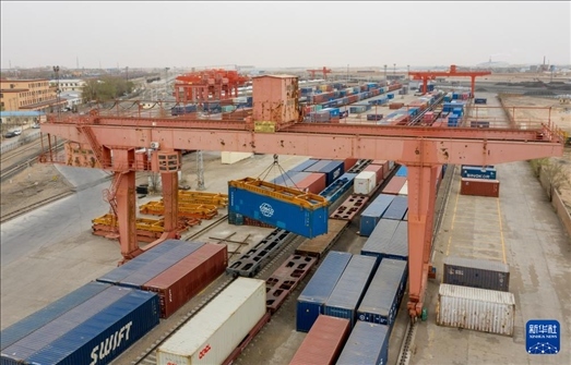 4月21日，二連浩特鐵路口岸龍門(mén)吊吊裝中歐班列集裝箱（無(wú)人機(jī)照片）。 新華社發(fā)（張海峰攝）