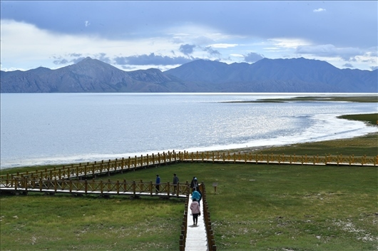 △ 游客行走在青?，敹嗫h冬格措納湖畔的木棧道上。