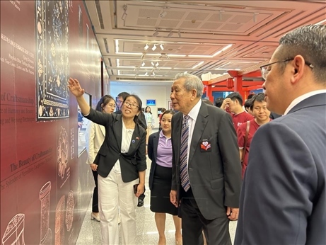 工作人員為泰國前副總理、泰中文化促進(jìn)委員會(huì)主席披尼講解展覽內(nèi)容。中國駐泰國大使館供圖