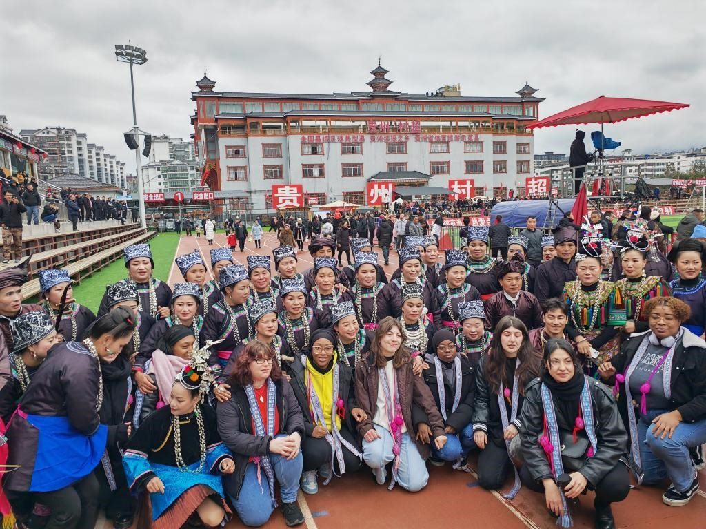 法國青年在“村超”賽場(chǎng)邊與參加表演的村民合影。新華社記者 羅羽 攝