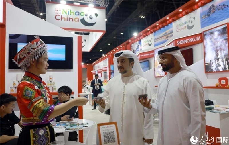 兩名阿聯(lián)酋觀眾在品嘗湖北名茶。人民網(wǎng)記者管克江攝