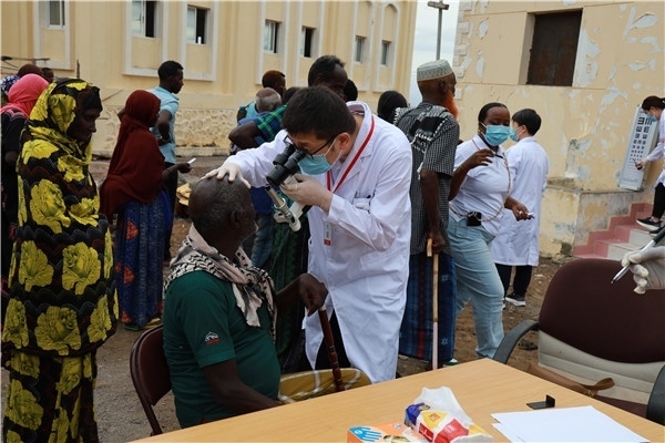 在義診現(xiàn)場(chǎng)，中國(guó)醫(yī)生與當(dāng)?shù)鼐用窈嫌傲裟?，吉布提鹽業(yè)投資公司供圖