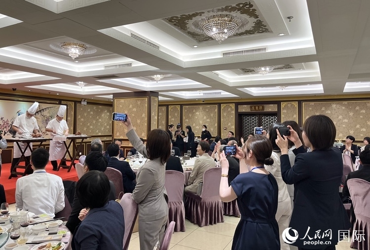 國家級非物質(zhì)文化遺產(chǎn)、全聚德片鴨工藝吸引代表團成員拍照留念。