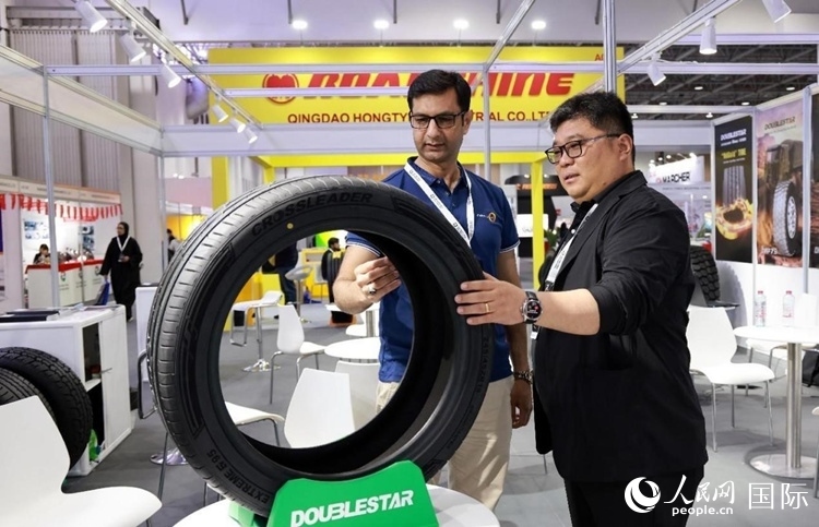 工作人員向客戶展示雙星電動汽車輪胎。和傳統(tǒng)汽車輪胎相比，電動汽車輪胎具有更高承載能力、更加靜音舒適、更好極速抓地、更低滾動阻力等特點。人民網(wǎng)記者 管克江攝