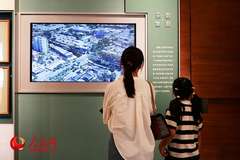 家長正在帶孩子參觀“輝煌中軸”專題展。人民網(wǎng)記者 韋衍行攝